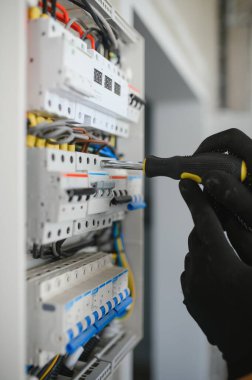 Devreler üzerinde çalışan elektrikçiye yakın çekim.