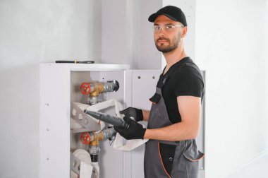 İşçi yangın söndürücüyü ve yangın hortumunu bina koridoruna yerleştirir veya denetler..