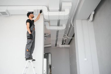 hvac hizmetleri, işçi havalandırma ve havalandırma için boru sistemi kurar.