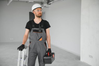 İnşaat alanında kaskı olan sevimli beyaz sakallı inşaat işçisi..