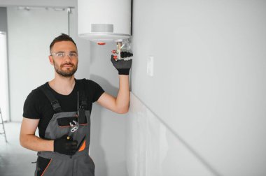 Profesyonel tesisatçı kazan dairesinde çalışıyor..