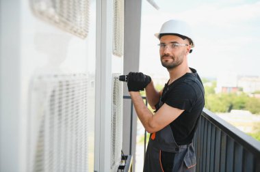 Teknisyen havalandırma ya da hava pompası üzerinde çalışıyor. HVAC servisi, bakım ve onarım.