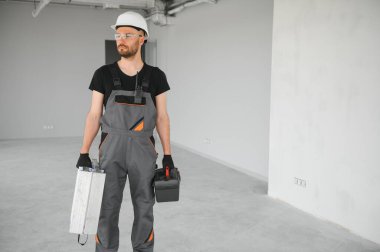 İnşaat alanında kaskı olan sevimli beyaz sakallı inşaat işçisi..