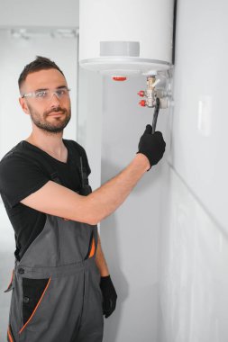 Profesyonel tesisatçı kazan ve boruları kontrol ediyor..