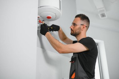 Profesyonel tesisatçı kazan dairesinde çalışıyor..