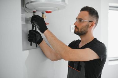 Profesyonel tesisatçı kazan dairesinde çalışıyor..