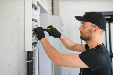 Bir erkek elektrikçi santralde çalışıyor..