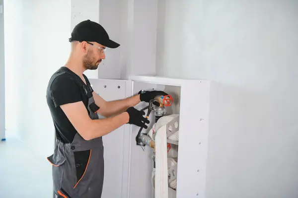 stock image The worker installs or inspects Fire extinguisher and fire hose reel in building corridor.