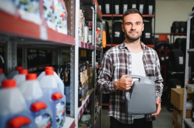 Otomobil deposunda motor yağı kutusu olan bir satıcı..