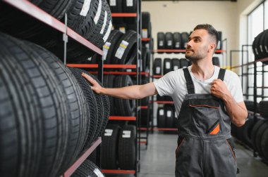 Araba servisindeki müşteri lastiği montajı, otomobil tamircisi güvenlik için lastiği ve lastik lastiği kontrol ediyor, konsept: makinelerin tamiri, hata tanısı, onarım. Adam araba tamirhanesinden alışveriş yapıyor.