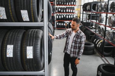 Araba servisindeki müşteri lastiği montajı, otomobil tamircisi güvenlik için lastiği ve lastik lastiği kontrol ediyor, konsept: makinelerin tamiri, hata tanısı, onarım. Adam araba tamirhanesinden alışveriş yapıyor.