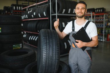 Mavi üniforma ayakta hisse senedi lastik tamircisi.