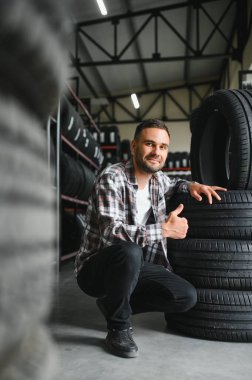 Araba servisindeki müşteri lastiği montajı, otomobil tamircisi güvenlik için lastiği ve lastik lastiği kontrol ediyor, konsept: makinelerin tamiri, hata tanısı, onarım. Adam araba tamirhanesinden alışveriş yapıyor.