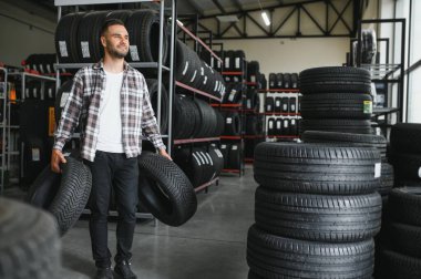 Araba servisindeki müşteri lastiği montajı, otomobil tamircisi güvenlik için lastiği ve lastik lastiği kontrol ediyor, konsept: makinelerin tamiri, hata tanısı, onarım. Adam araba tamirhanesinden alışveriş yapıyor.