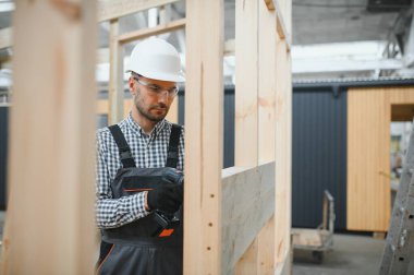 Modüler bir ev montajlayan işçi marangoz..