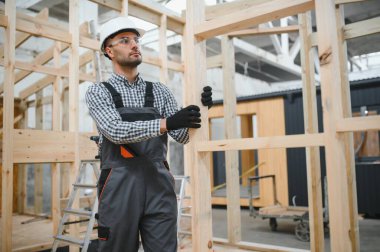 Yeni ve modern modüler evin inşaatı. Özel koruma üniformalı işçiler enerji tasarruflu mülklerin geliştirme endüstrisinde çalışıyor..