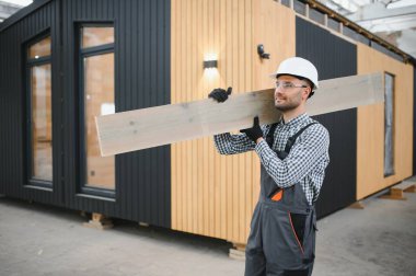 Yeni ve modern modüler evin inşaatı. Özel koruma üniformalı işçiler enerji tasarruflu mülklerin geliştirme endüstrisinde çalışıyor..