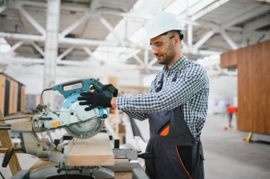 Üniformalı bir işçi ya da mühendis ahşap modüler evler için inşaat alanında çalışıyor..