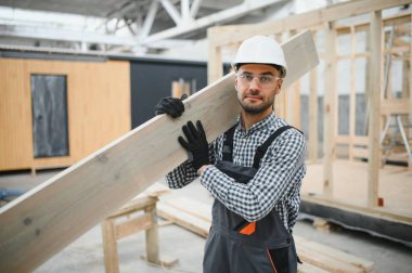 Yeni ve modern modüler evin inşaatı. Özel koruma üniformalı işçiler enerji tasarruflu mülklerin geliştirme endüstrisinde çalışıyor..