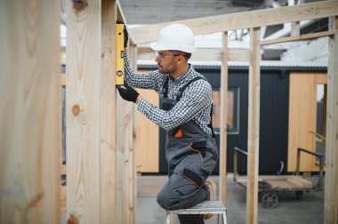 Yeni ve modern modüler evin inşaatı. Özel koruma üniformalı işçiler enerji tasarruflu mülklerin geliştirme endüstrisinde çalışıyor..