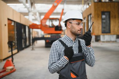 Bir işçi modüler evi kamyona yükleme işlemini kontrol eder. Ulaşım ve teslimat kavramı.