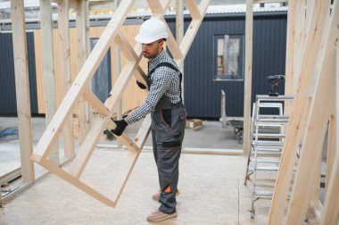 Yeni ve modern modüler evin inşaatı. Özel koruma üniformalı işçiler enerji tasarruflu mülklerin geliştirme endüstrisinde çalışıyor..