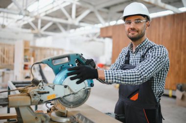 Üniformalı bir işçi ya da mühendis ahşap modüler evler için inşaat alanında çalışıyor..
