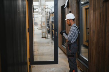 Yeni ve modern modüler evin inşaatı. Özel koruma üniformalı işçiler enerji tasarruflu mülklerin geliştirme endüstrisinde çalışıyor..