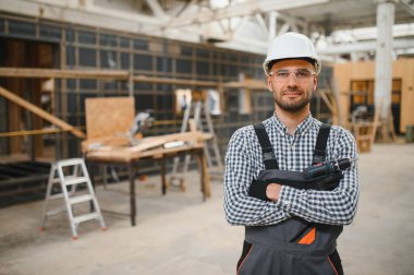 Prefabrik ahşap evin yanındaki üniformalı işçinin portresi..