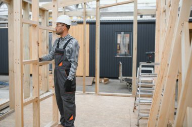 Yeni ve modern modüler evin inşaatı. Özel koruma üniformalı işçiler enerji tasarruflu mülklerin geliştirme endüstrisinde çalışıyor..