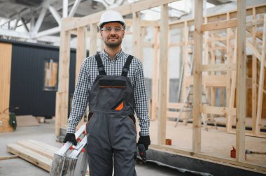 Yeni ve modern modüler evin inşaatı. Özel koruma üniformalı işçiler enerji tasarruflu mülklerin geliştirme endüstrisinde çalışıyor..