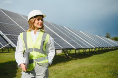 Genç kadın ekoloji mühendisi fotovoltaik güneş çiftliği konsepti olan yeşil enerji güneş panelleri hakkında verimli bilgiler topladı.