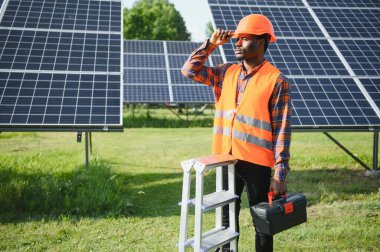 Afrikalı Amerikalı elektrikçi güneş panelleri kuruyor. Yeşil enerji.