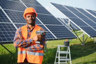 Afrikalı Amerikalı elektrikçi güneş panelleri kuruyor. Yeşil enerji.