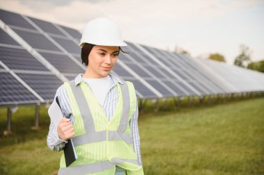Güneş panellerinin arasında duran güzel kadın mühendisin portresi..