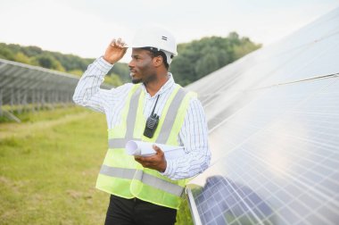 Yenilenebilir enerji, sürdürülebilirlik ve çevre için bir çiftlikte insan, mühendis ve güneş paneli.