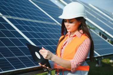 Güneş panelleri açık havada yakınındaki güzel genç kadın.