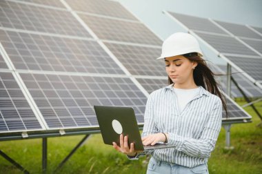 Güneş panellerinin arasında duran güzel kadın mühendisin portresi..