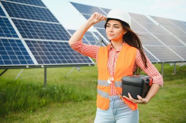 Güneş panelleri açık havada yakınındaki güzel genç kadın.