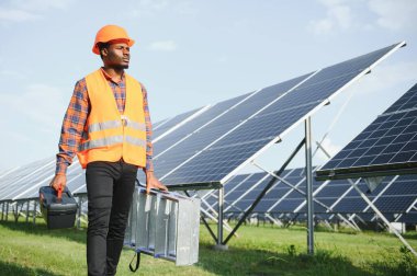 Afrikalı Amerikalı elektrikçi güneş panelleri kuruyor. Yeşil enerji.