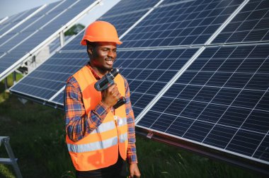 Afrikalı Amerikalı elektrikçi güneş panelleri kuruyor. Yeşil enerji.