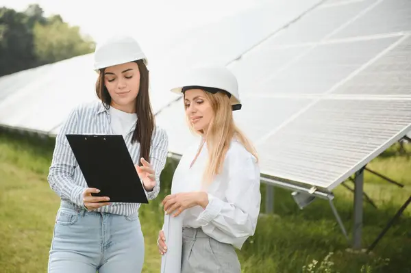 stock image Portrait of female engineers spending time outside near solar panels.