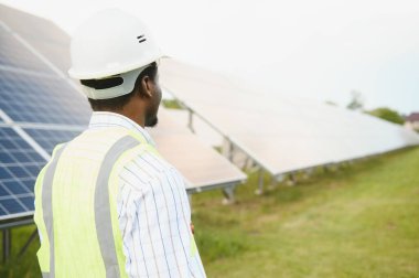 Yenilenebilir enerji, sürdürülebilirlik ve çevre için bir çiftlikte insan, mühendis ve güneş paneli.