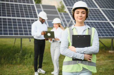 Bir grup mühendis güneş paneli çiftliğinde çalışıyor.