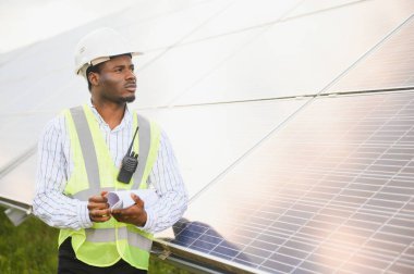 Yenilenebilir enerji, sürdürülebilirlik ve çevre için bir çiftlikte insan, mühendis ve güneş paneli.