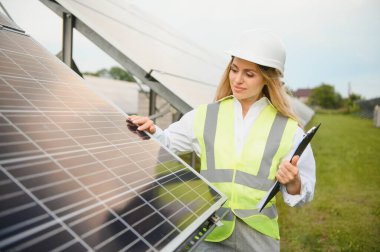 Pano konumu güneş panelleri açık havada yakın olan güzel genç mühendis.