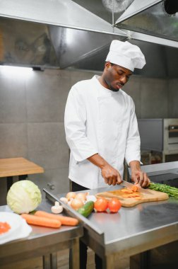 Afro-Amerikalı aşçı restoran mutfağında mutfak tezgahında duruyor..