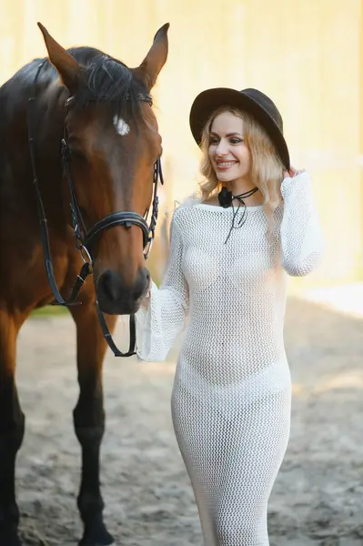 young woman in a dress with a horse.