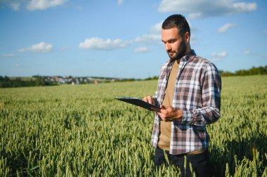 Buğday tarlasında duran çiftçinin portresi.