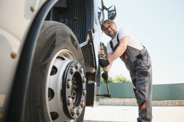 Caucasian Professional Truck Mechanic Rebuilding Heavy Duty Truck Diesel Engine. Automotive Industry Theme.